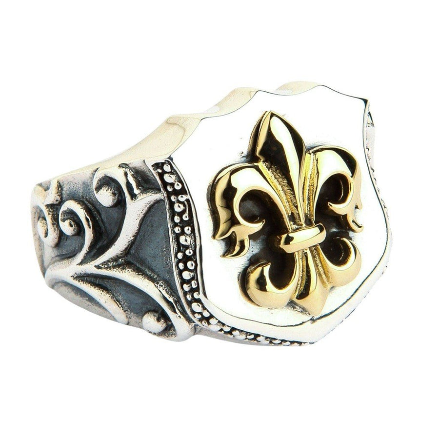 Gouden fleur-de-lis schildring van sterling zilver met gedetailleerde krulmotieven en verguld middelpunt op gepolijst zilver.