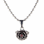 A gothic-style silver rose pendant with a garnet hanging from a sterling silver ball chain.