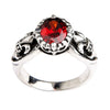 Gothic sterling silver ring with brilliant red garnet stone and fleur de lis design on white background