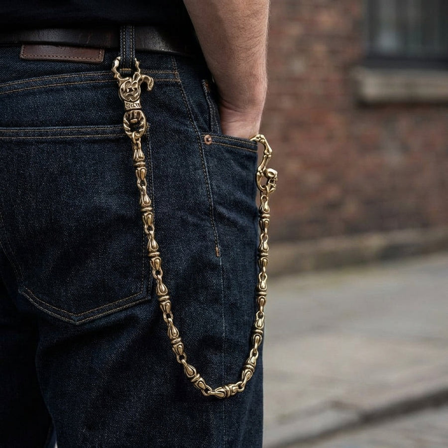 Gothic kranium messing pengeclips kæde båret på mørke denim jeans, der viser drapering og pasform