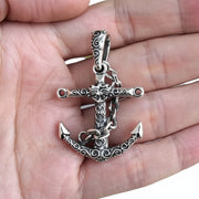 The handmade silver anchor pendant held in hand to demonstrate its size and substantial feel.
