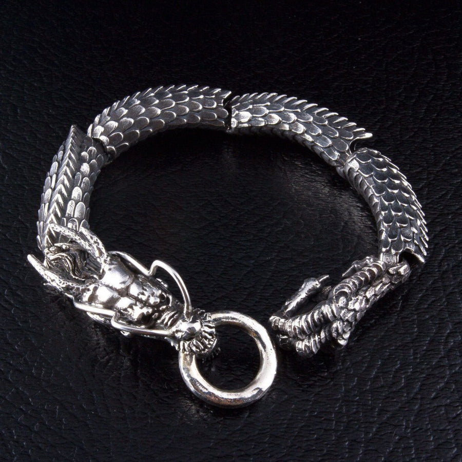 Japanese dragon sterling silver bracelet with dragon mouth ring clasp on black leather background