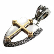 An angled view of the Knight's Shield Pendant, showing the gold cross and hammered silver texture.