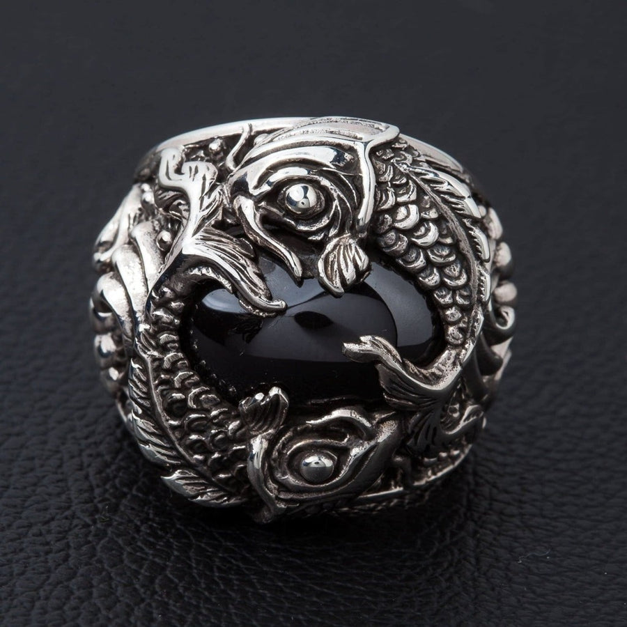 Anel de peixe koi em prata esterlina com cabochão de ónix preto, vista frontal mostrando o design de peixes gêmeos.