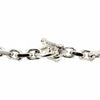Un acercamiento del broche T-bar de calavera de ojo de granate rojo en la cadena de plata con borde para hombres.