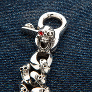 Close-up shot highlighting the red garnet stone set in the silver skull's eye socket.