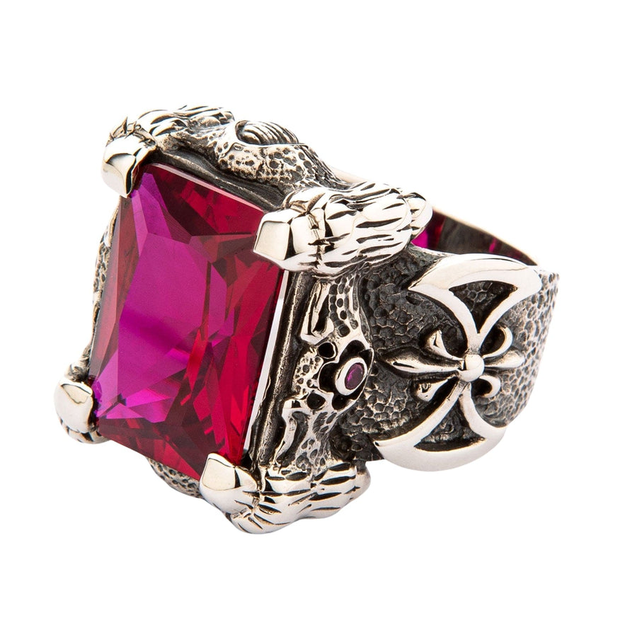 Anello grande in argento sterling a forma di artiglio di drago che tiene una massiccia pietra rettangolare di rubino rosso su uno sfondo bianco.