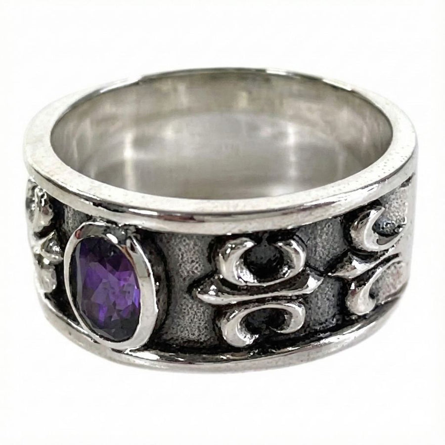 Ángulo lateral del anillo que muestra la intrincada talla gótica de Fleur De Lis y el acabado oxidado.