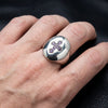 Man met de amethyst kruisring op de wijsvinger, die demonstreert de 18mm x 22mm grootte.