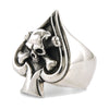 Angled on white, the wide sterling silver band rising to a spade face with oxidized recesses behind the crossbones