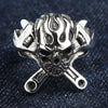 Ring med brinnande dödskalle i 925 sterling silver med korsade skiftnycklar, frontvy på jeansbakgrund