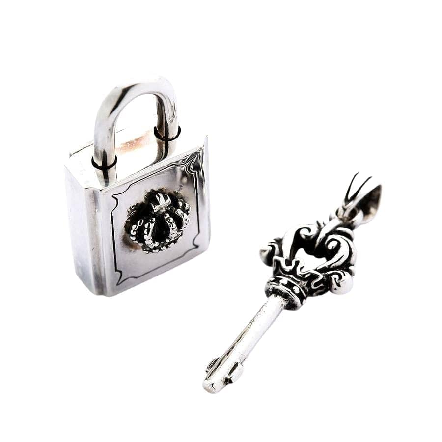 Un conjunto de colgantes de plata de ley con un candado con corona funcional y una llave ornamentada.