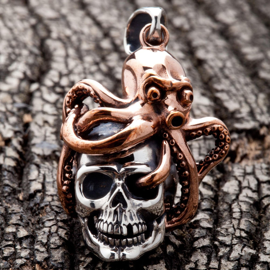 Una vista frontal del colgante de cráneo de pulpo de dos tonos, mostrando el kraken de bronce envolviendo un cráneo de plata esterlina.