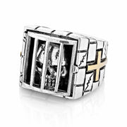 A solid sterling silver and gold prisoner skull ring, showing a detailed skull behind the bars of a prison cell.