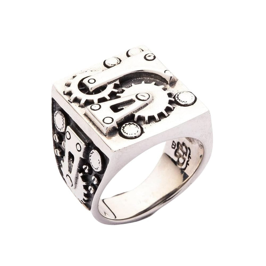 Primo piano dei dettagli ispirati ai motori industriali sull'anello da biker da uomo.
