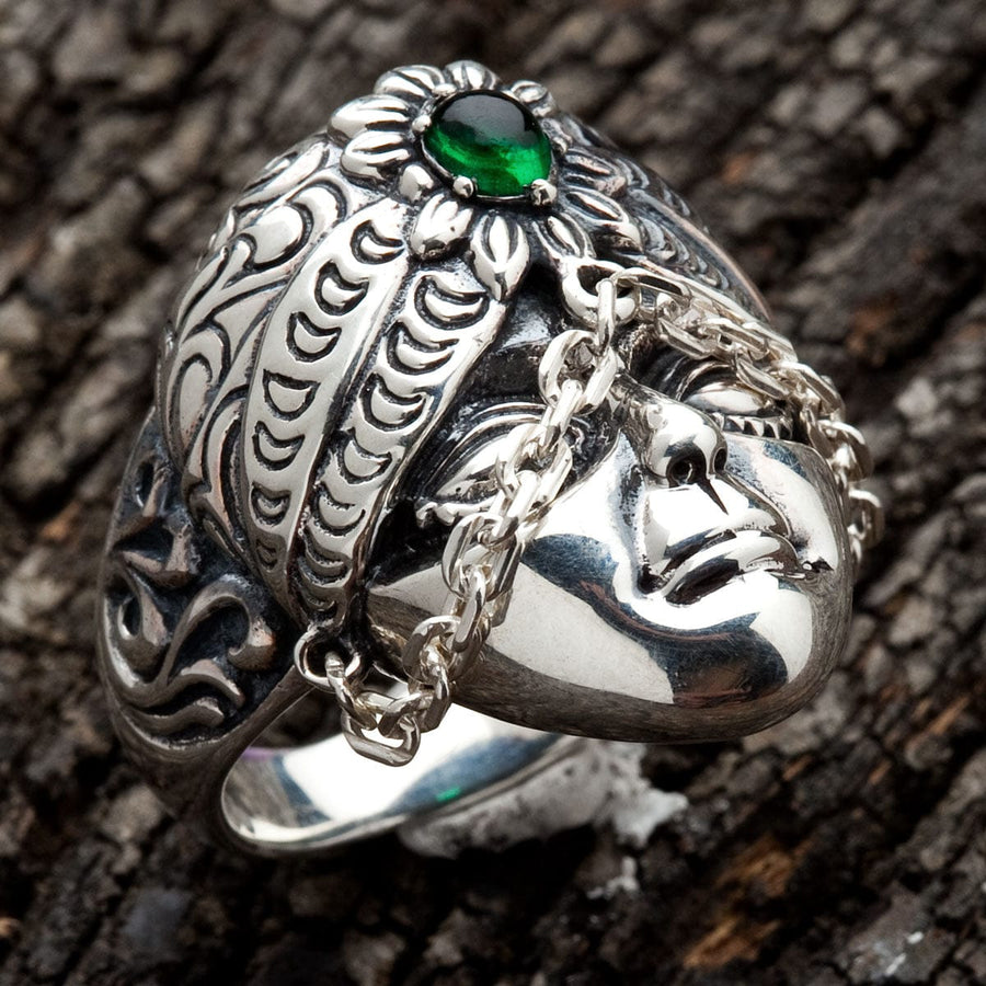 Un anillo de plata esterlina con una cara tribal de Bali detallada, un turbante ornado y una piedra verde.