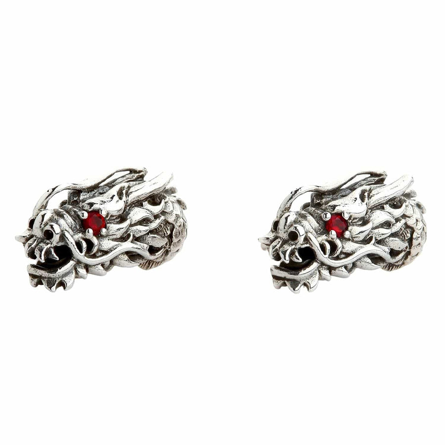 Une paire de boucles d'oreilles tête de dragon en argent sterling avec des yeux en grenat rouge.