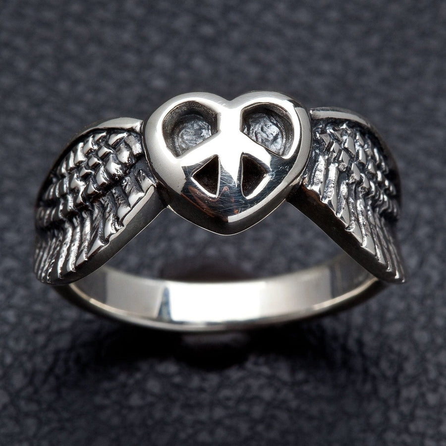 Een unisex solide zilveren ring met een gevleugelde hart en een vredesymbool in het midden.